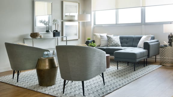 a living room with couches and chairs and a rug