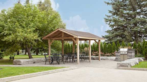 a pavilion with a table and chairs in a park