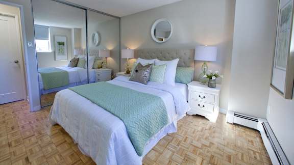 a bedroom with two beds and a mirrored closet