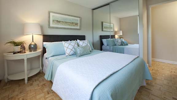 a bedroom with two beds and a mirrored closet