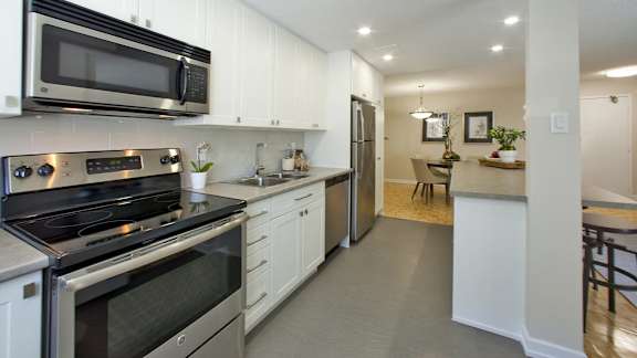 a kitchen with stainless steel appliances and white cabinets