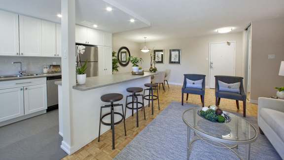 a living room with a kitchen and a table with chairs