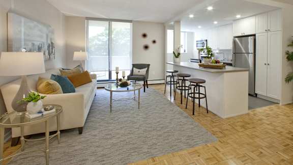 a living room with a couch and a kitchen with a bar