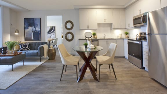a kitchen and living room with a table and chairs