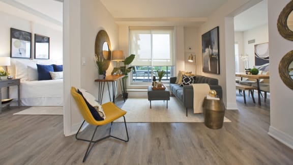 a living room with a couch and a chair and a window