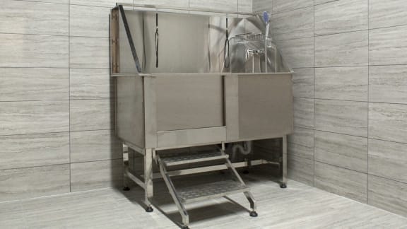a stainless steel sink with a cart in a bathroom