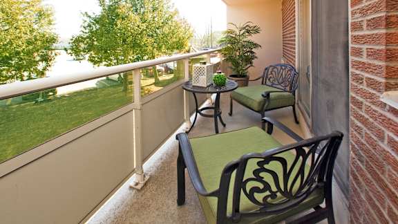 a balcony with chairs and a table on a balcony