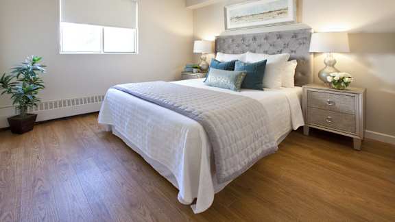 a bedroom with a bed and a dresser and a window