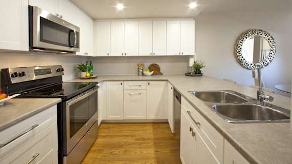 a large kitchen with stainless steel appliances and white cabinets