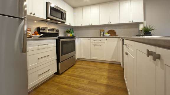a kitchen with white cabinets and stainless steel appliances