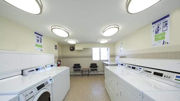 a laundry room with washers and dryers and a table with chairs
