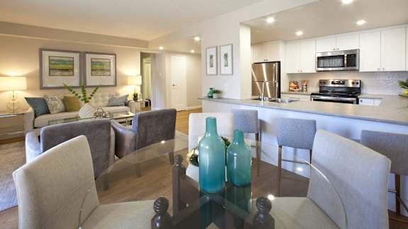 a living room and kitchen with a table and chairs