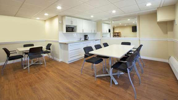 a conference room with a table and chairs and a kitchen