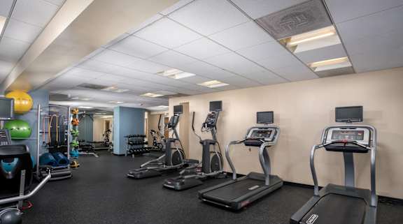 A gym with treadmills, exercise bikes, and other equipment.