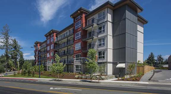 A modern apartment building with a red and grey facade.