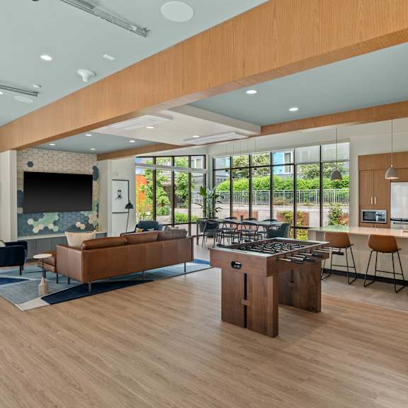 A modern living room with a kitchen area in the background.