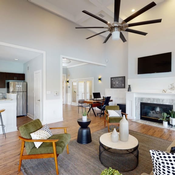 a clubhouse with a fireplace and a ceiling fan at Ashford Green, North Carolina