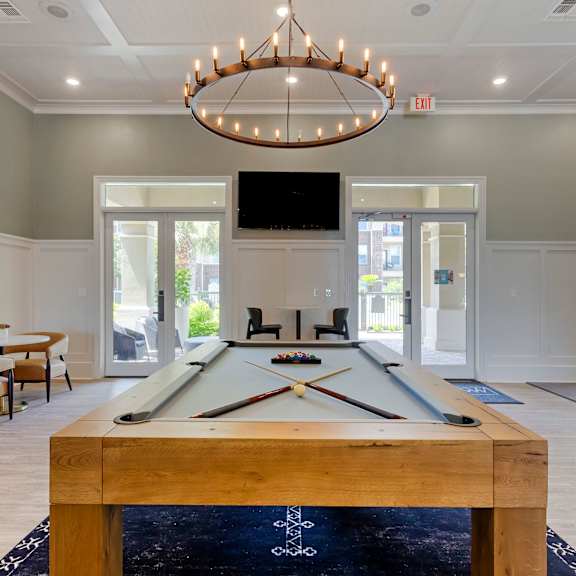 Resident Lounge with Pool Table and Ring Shaped Chandelier at Madison on the Meadow in Stafford, TX