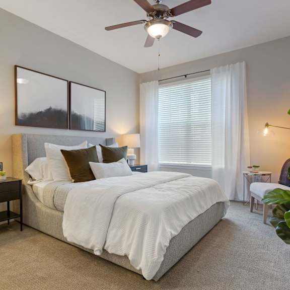 a bedroom with a large bed and a ceiling fan at Madison on the Meadow in Stafford, Texas