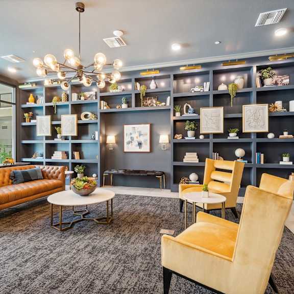 A living room with a brown sofa, a coffee table, and a chandelier.
