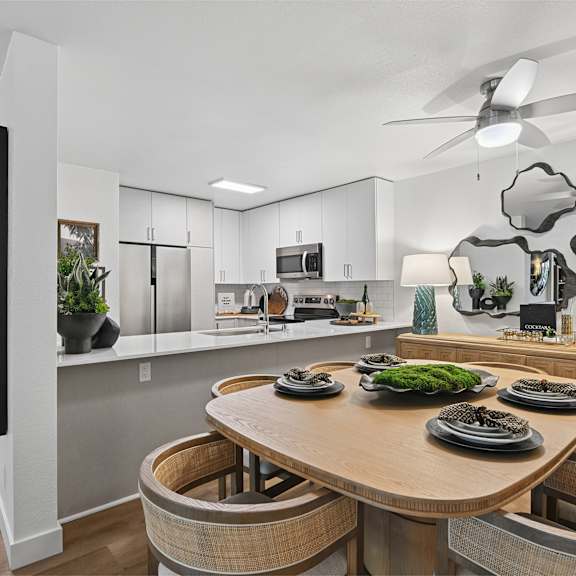 A modern kitchen with a wooden table and chairs.