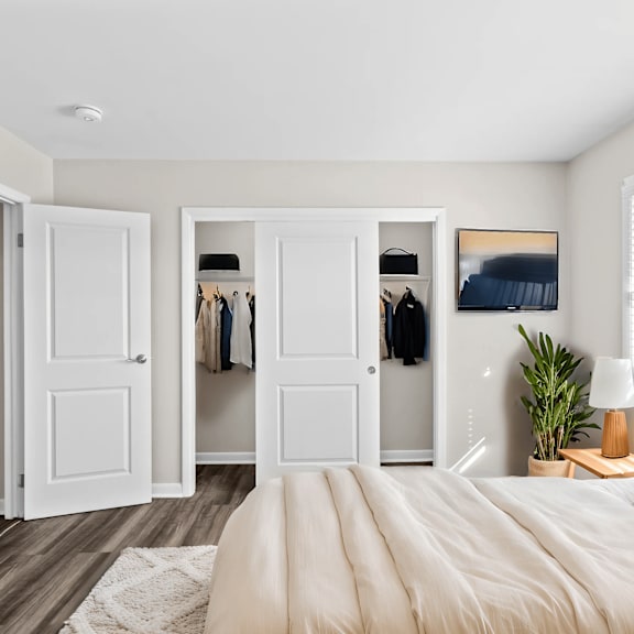 A bedroom with a large bed, a dresser, and a mirror.
