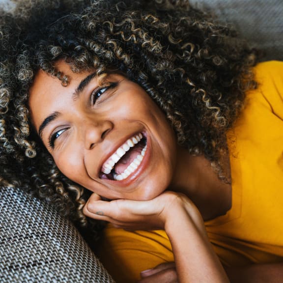 a woman smiling while laying on a couch at Fiore Townhomes, Venice, Florida