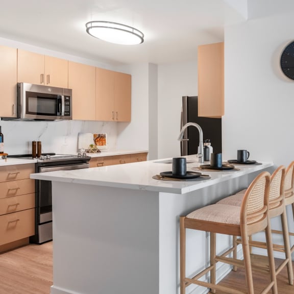 a kitchen with an island with two stools in front of it