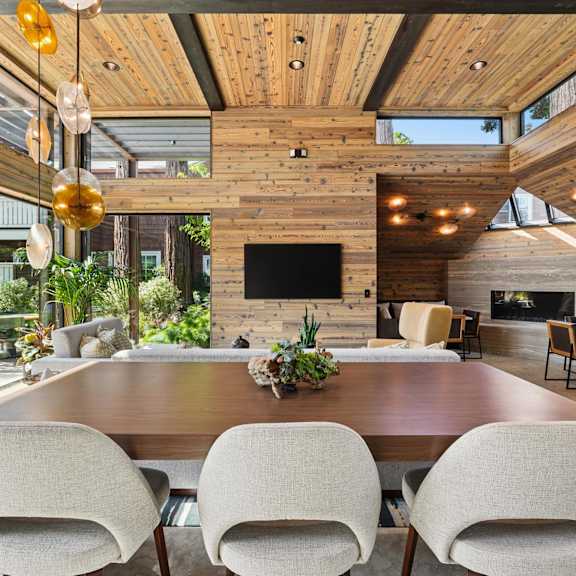 A pool area with a chair and table overlooking a body of water.