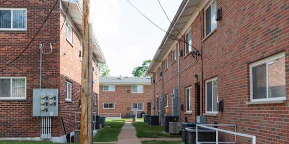 A long brick building with a walkway in between.