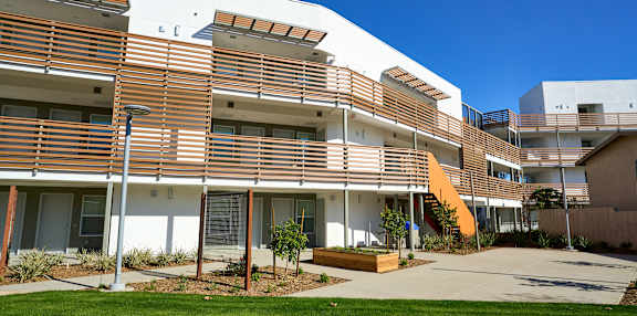 A modern building with a green lawn in front.