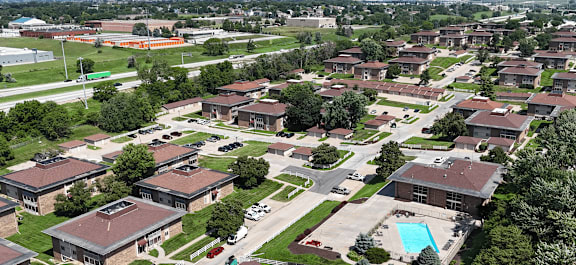 A large brick building with a green lawn in front.
