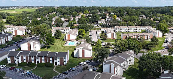 A large brick building with a green lawn in front.