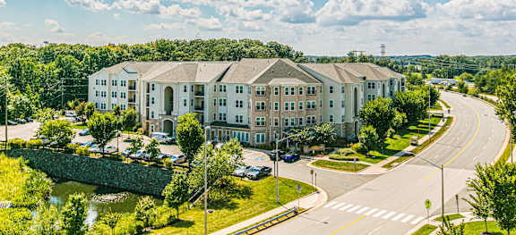 A large white building with a green lawn in front.