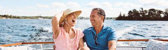 a man and woman sitting on a boat in the water