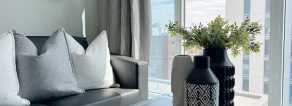 a living room with a couch and a table with a vase