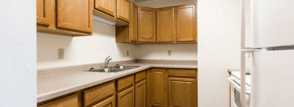 Bismarck, ND Arbor 404 |a kitchen with wooden cabinets and a sink and a refrigerator