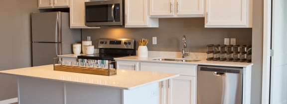 a kitchen with white cabinets and stainless steel appliances at 29 West, Fargo, 58104