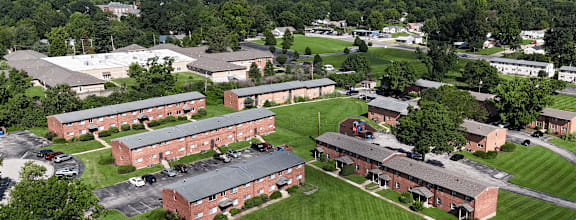 A large building complex with a green lawn in front.