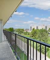 A balcony overlooks a residential area with houses and apartment buildings at Independence Place Apartments, Parma Heights, OH