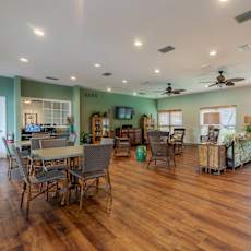 A spacious room with wooden floors and a dining table set up with chairs. at Imperial Gardens Apartments, Clearwater, FL, 33764