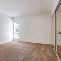 bedroom with window and mirrored closet doors