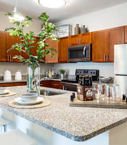 A kitchen with a granite countertop and a white chair.
