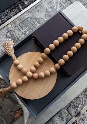 A wooden rosary with a tassel rests on a black box. at Two Rivers Home Rentals, West Des Moines, IA