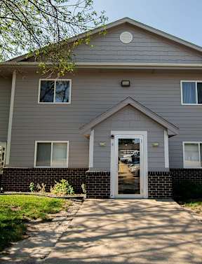 a white house with a sidewalk in front of it at Peach Tree Apartments, Ankeny, Iowa