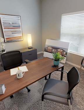 A conference room with a long table, chairs, and a framed picture on the wall at The Barclay Apartments, Altoona, IA, 50009