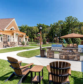 A backyard with a stone patio and a fire pit.