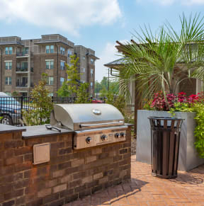 a barbecue grill on a brick wall next to a trash can at Residence at Riverwatch in Augusta, GA 30909