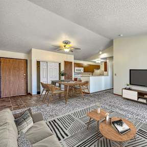 A living room with a television, a dining table, and a couch. at Somerset Apartments, Des Moines, IA, 50315