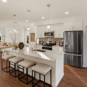A modern kitchen with a large island and stools. at The Narrows at Clare Apartments , Apartments, Bremerton, WA